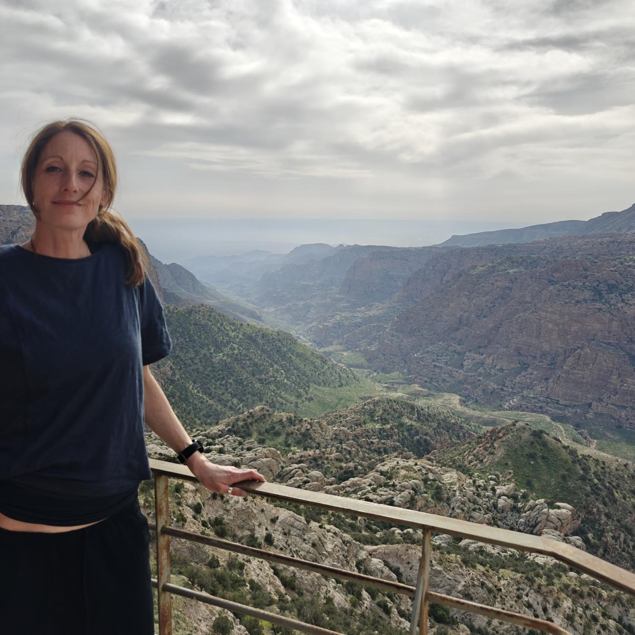 Woman stood in front of a view of a valley in Jordan