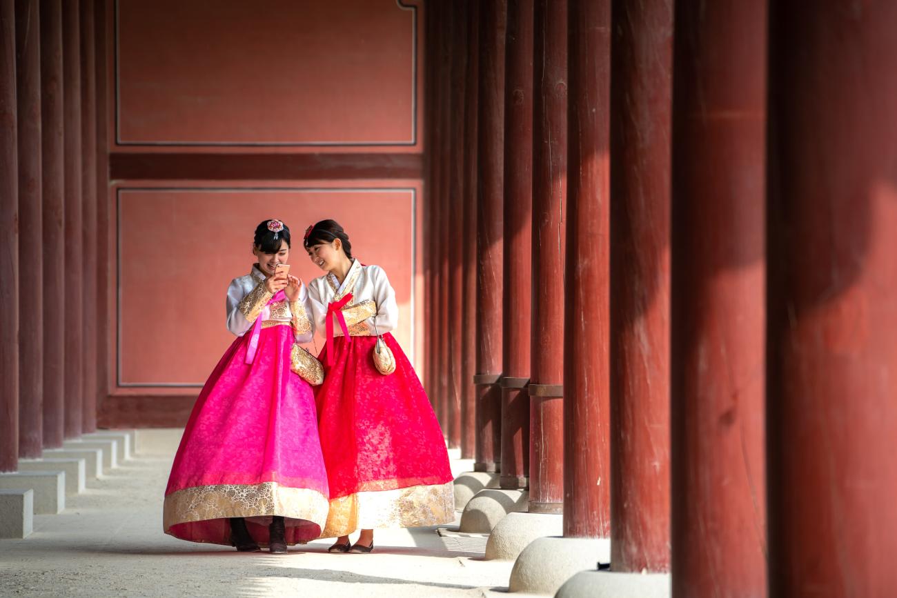 Two Korean girls walking and wearing traditional clothes called hanbok